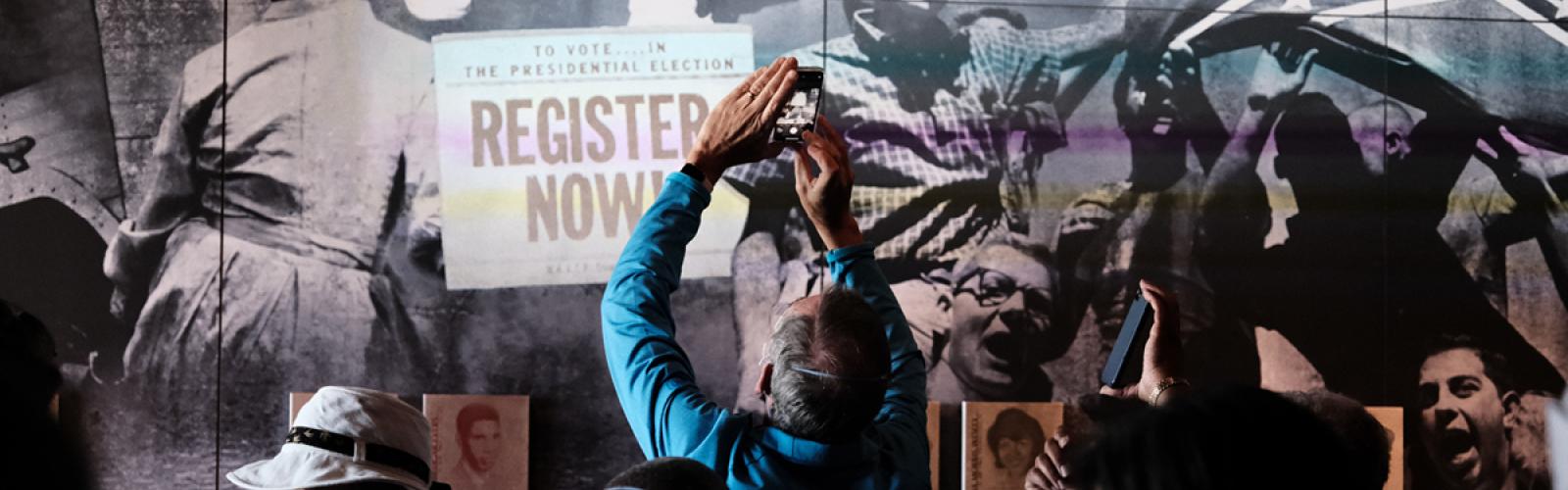 Man taking picture in Civil Rights Tour exhibit