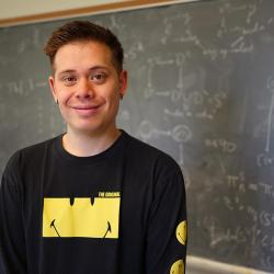 JD Quigley in front of blackboard